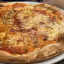 The image is a well-composed and photo-realistic close-up of a pizza. The main subject is sharp and in focus, and the colors appear accurate and natural. The lighting is generally good and even.