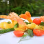 The image is a well-lit and photo-realistic depiction of a food dish featuring fried shrimp, asparagus, and cherry tomatoes. The colors are vibrant and appear accurate, enhancing the appeal of the meal. The main subjects are sharp and in focus with a pleasant shallow depth of field that blurs the background.