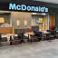 An image of the interior of a McDonald's restaurant, featuring seating areas, the counter, and the prominent McDonald's sign. The lighting is good, and the image is sharp.